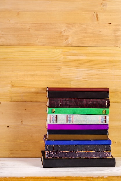 Pile de vieux livres sur une étagère en bois