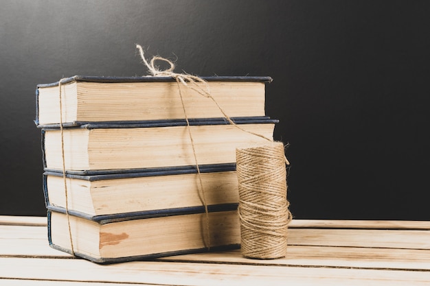 Pile de vieux livres reliés sur une surface en bois avec espace de copie.