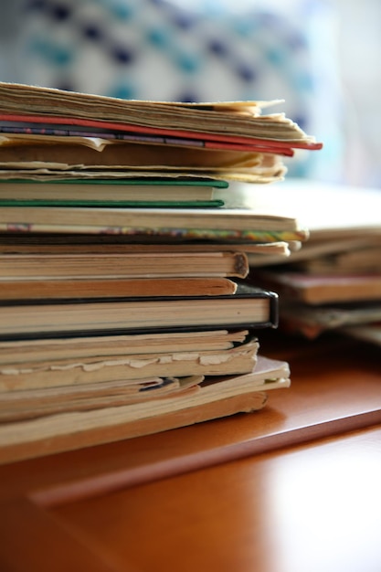 Pile de vieux livres sur une table marron dans la chambre se bouchent