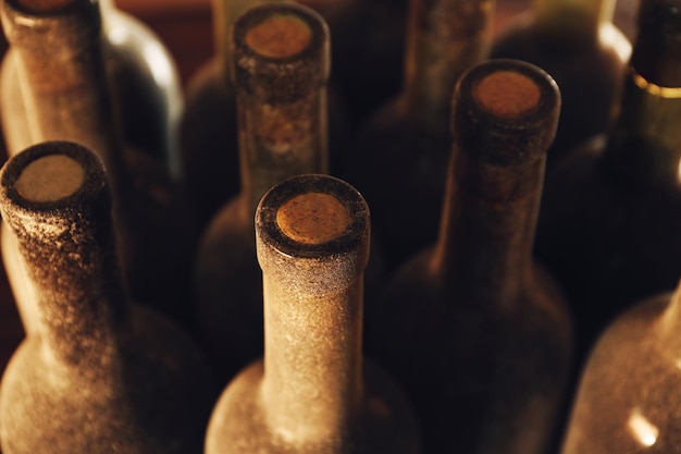 Piles de bouteilles de vin poussiéreuses sur fond de bois vue à l'envers Close up