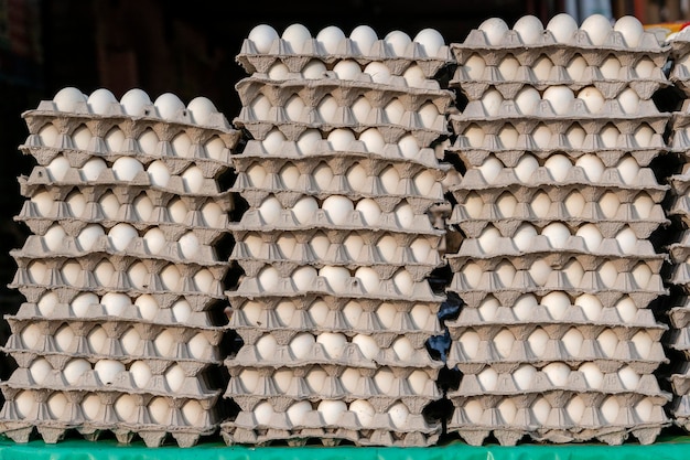 Piles d'œufs blancs dans des plateaux sur le marché de rue local en Inde