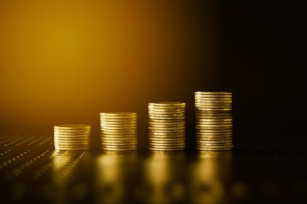 Des piles de pièces d'argent en or sur fond noir Concept d'entreprise et d'économie d'argent