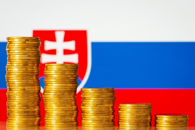 Piles de pièces d'or du plus haut au plus bas avec le drapeau de la Slovaquie en arrière-plan Concept de diminution économique crash d'automne Taux financier négatif en Slovaquie