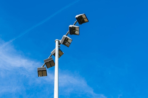 Un pilier avec des projecteurs au-dessus du stade contre le ciel bleu