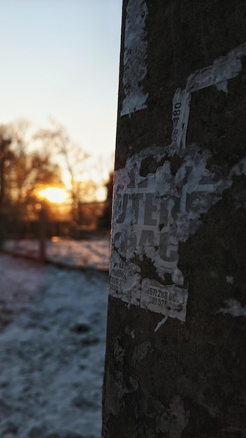 Pilier avec de vieilles annonces sur fond de coucher de soleil