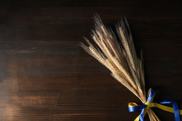 Épillets avec des rubans de couleurs du drapeau ukrainien sur fond de bois