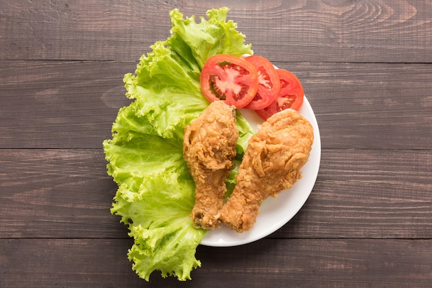 Pilon de poulet frit à la tomate sur fond de bois