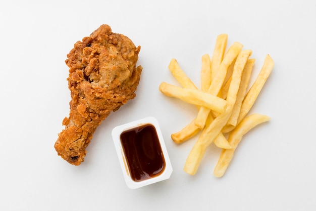 Pilon de poulet frit vue de dessus avec frites et sauce