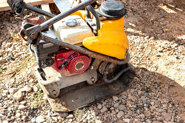 Pilonneuse vibrante avec plaque vibrante sur un chantier de construction Compactage du sol avant la pose de dalles de pavage Gros plan