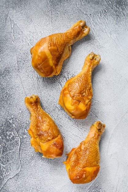 Pilons de cuisse de poulet fumé sur une table de cuisine sur tableau blanc. Vue de dessus.