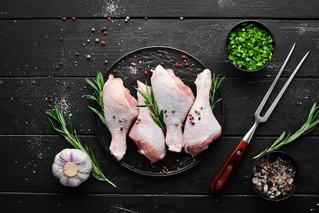 Pilons de poulet crus aux épices et légumes au romarin Vue de dessus Espace libre pour votre texte