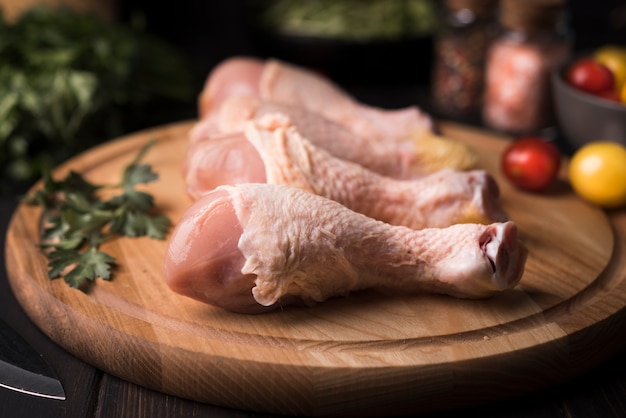 Photo pilons de poulet gros plan sur planche de bois avec des ingrédients