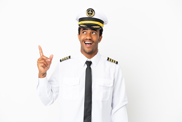 Pilote d'avion afro-américain sur fond blanc isolé pointant vers le haut et surpris