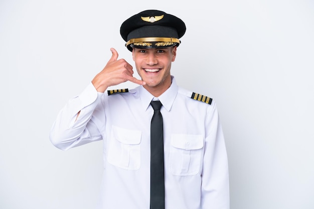 Pilote d'avion caucasien isolé sur fond blanc faisant un geste de téléphone Call me back sign