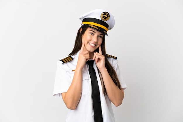 Pilote d'avion fille brésilienne sur fond blanc isolé souriant avec une expression heureuse et agréable