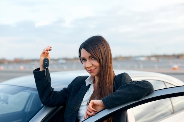 Pilote de femme heureuse montrant les clés de voiture