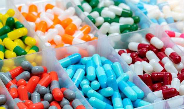 Pilule de capsules colorées dans une boîte en plastique. Produits de pharmacie.