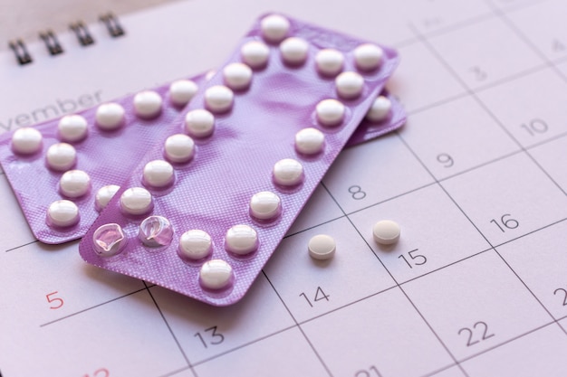 Pilule contraceptive avec date de fond de calendrier, concept de soins de santé et médecine