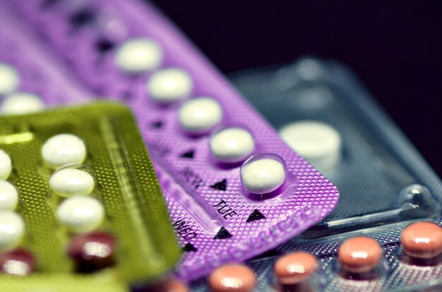 Pilule contraceptive orale sur fond noir.