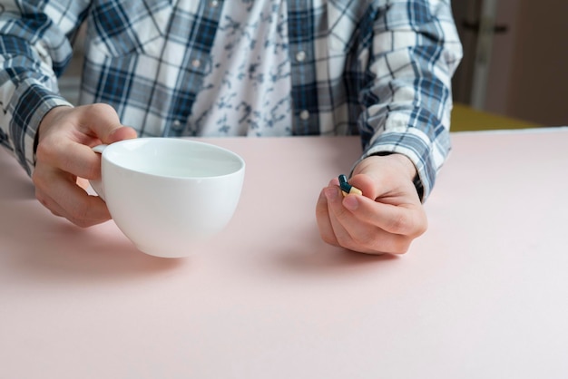 Une pilule de médecine du matin, des comprimés à la main et un verre d'eau