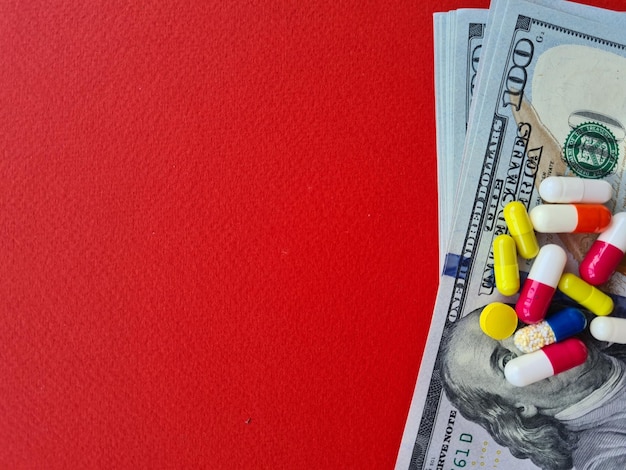 Pilules d'argent de médecine sur des billets d'un dollar sur le fond rouge