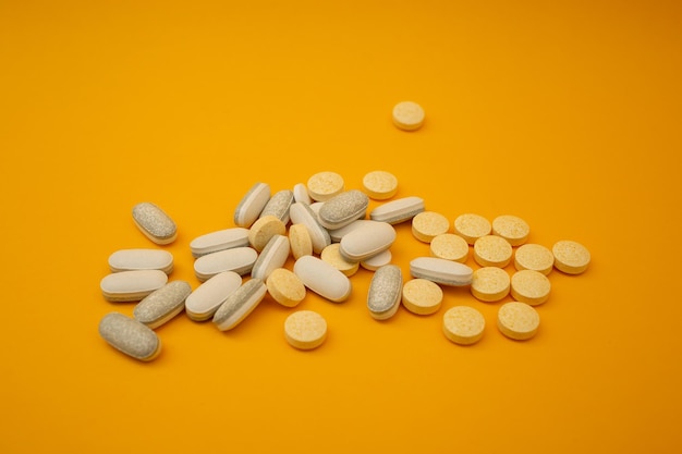 Pilules blanches sur un thème médical de fond jaune