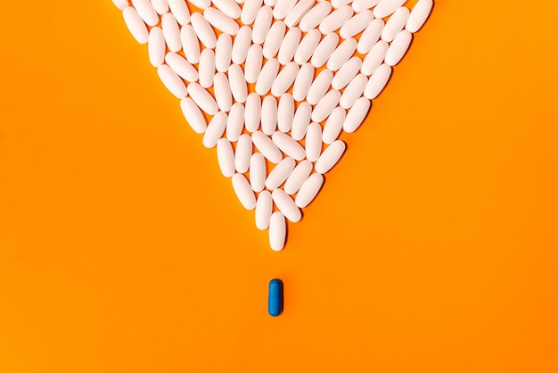 pilules bleues et blanches sur fond abstrait orange