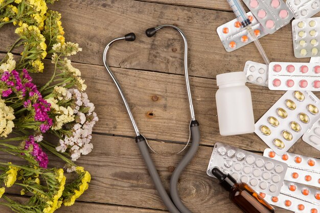 Pilules bouteille médicale seringue et stéthoscope sur table en bois marron