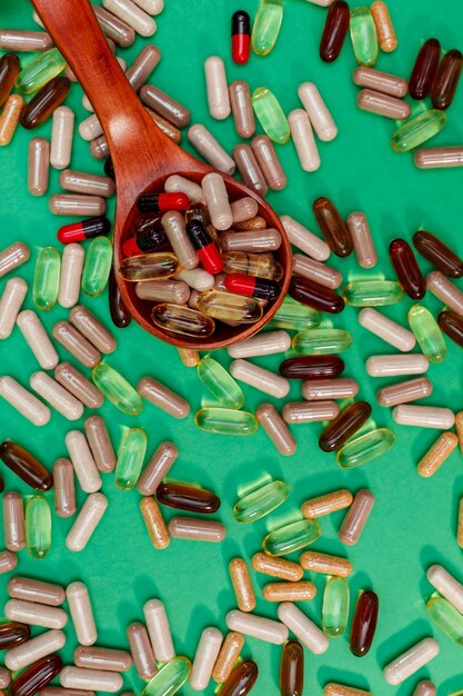 Photo pilules et capsules multicolores sur fond vert