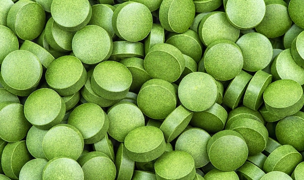 Pilules de chlorella verte sur fond blanc