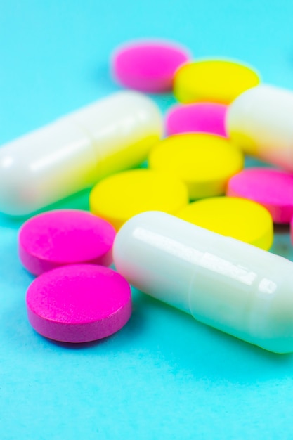 Photo pilules et comprimés colorés sur fond vert. fermer. concept de traitement médical.