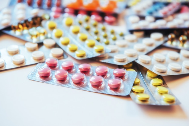 Des pilules de différentes couleurs se trouvent à la surface dans un emballage scellé