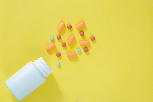 Pilules et flacons de médicaments sur fond jauneToutes sortes de médicaments à mettre dans