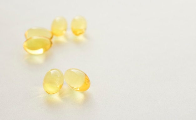 Pilules jaunes d'huile de poisson sur fond blanc