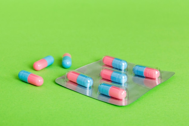 Pilules de médecine sur fond clair Médicaments et pilules de prescription fond plat Comprimés médicaux bleus et roses sous blister