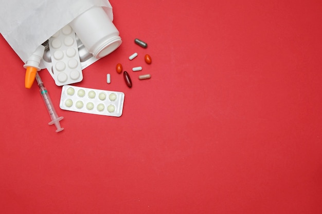 Photo pilules de médecine sur fond rouge, espace pour le texte. concept de pharmacie de médecine