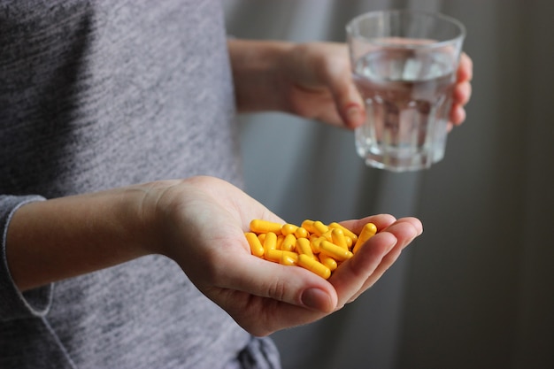 Les pilules médicales dans les mains des femmes prennent des pilules, des vitamines, des additifs alimentaires