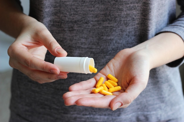 Les pilules médicales dans les mains des femmes prennent des pilules, des vitamines, des additifs alimentaires