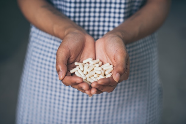 Pilules et médicaments dans les mains des femmes, les drogues dangereuses ont des effets néfastes sur la santé.