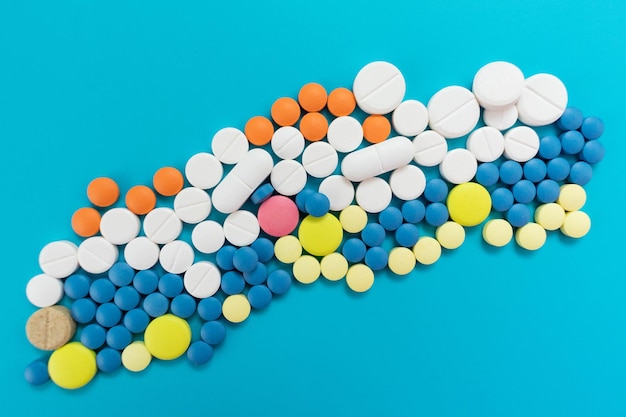 Pilules multicolores sur fond bleu. Antécédents médicaux.
