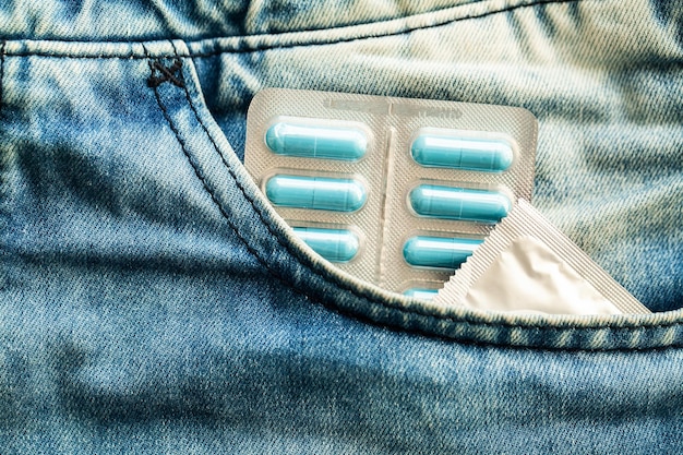 Pilules de puissance médicale et préservatif sur jeans