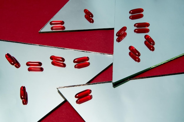 Photo pilules rouges dans une capsule sur le miroir