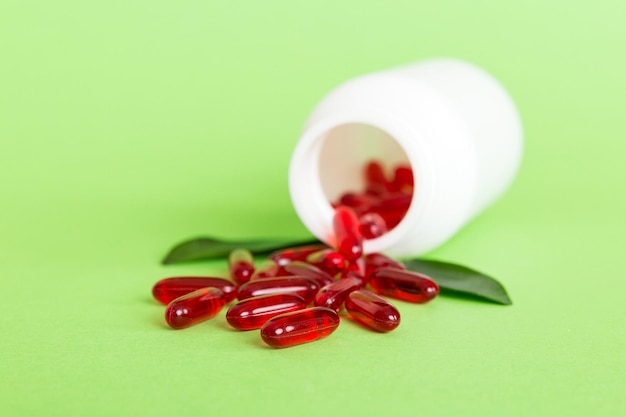 Pilules rouges renversées autour d'une bouteille de pilules Médicaments et pilules sur ordonnance fond plat Capsules médicales rouges