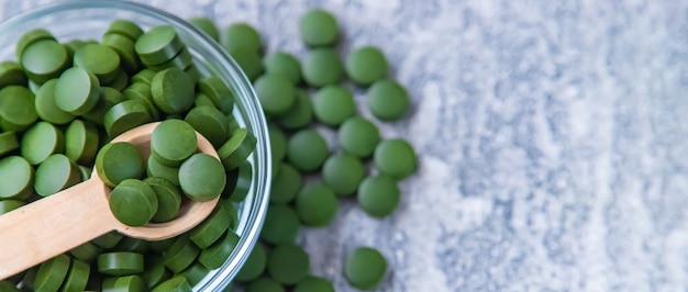 Pilules vertes de chlorella et de spiruline. Boisson à mise au point sélective