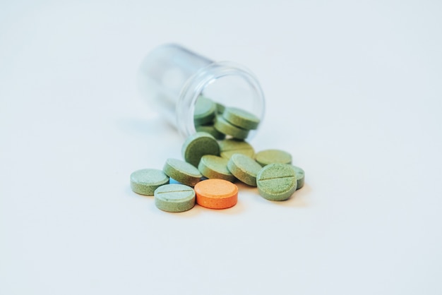 Pilules vertes médicales pour le traitement et les soins de santé sur fond blanc