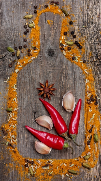 Photo piment, ail, anis étoilé et épices sur fond de bois ancien