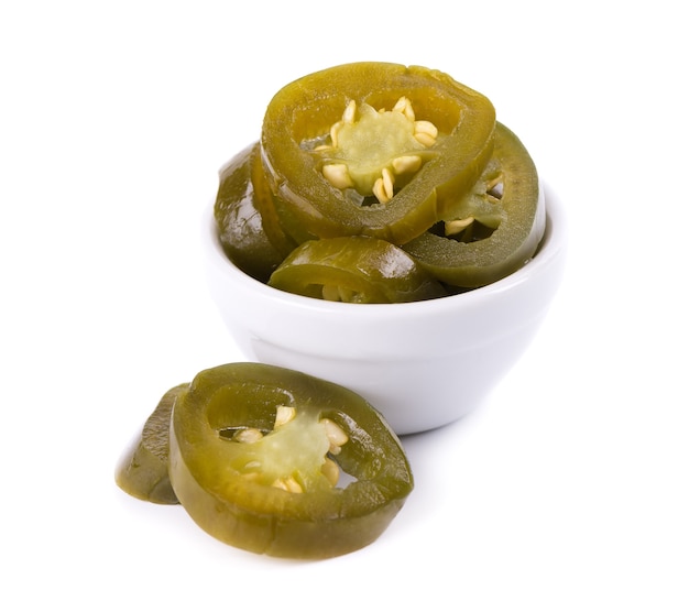 Piment jalapeno mariné dans un bol en céramique isolé sur fond blanc tranches de serrano chaud conservé