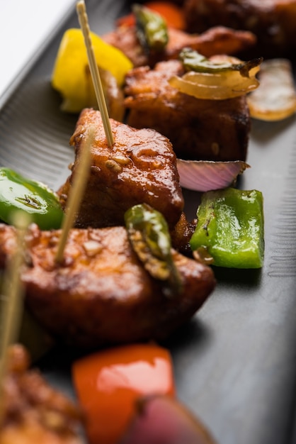 Piment paneer ou fromage cottage épicé, servi dans un plat blanc avec poivron et oignon, menu de démarrage indien préféré, mise au point sélective