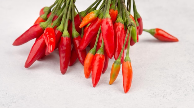 Piment rouge chaud sur fond blanc texturé, ingrédients pour la nourriture épicée, espace de copie