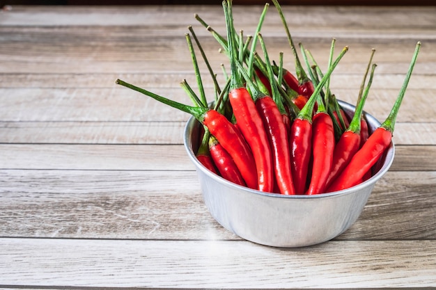 Piment rouge dans un bol sur une table en bois